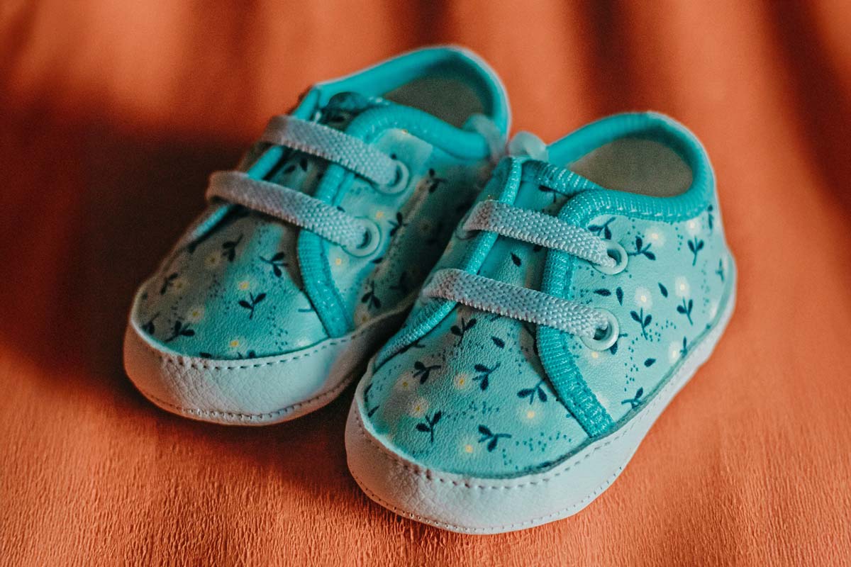 Baby shoes on an orange curtain