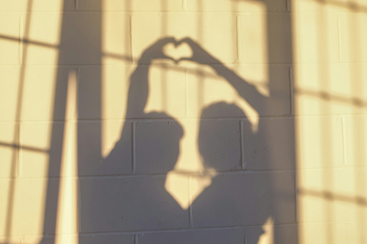 People making a heart sign with their shadows 